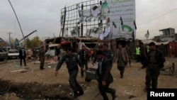 Afghan police and officials carry body parts away from the scene of a suicide attack in Kabul blamed on the Taliban.