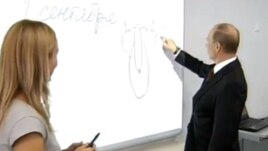 Владимир Путин тақтаға сурет салып тұр.