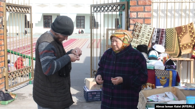 A trader outside a mosque in Bishkek