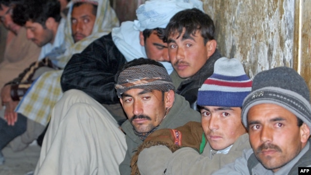 Detained Afghan immigrants sit in a Pakistani security cell in Quetta, just some of the thousands who flee the country every year.