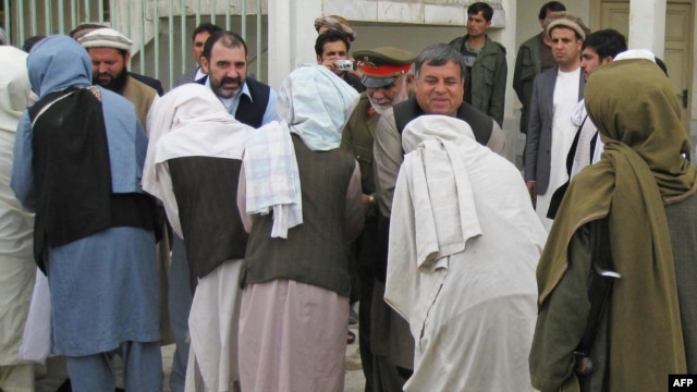 Kandahar Governor Tooryalai Wesa (right, facing camera) greets Taliban fighters as they peacefully surrender arms during a meeting with Afghan government officials as part of the government's peace and reintegration process in Kandahar in 2011.