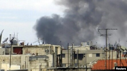 Smoke rises in the city of Homs during violence in January