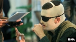 Iranian acid attack victim, Davood Roshanayi, talks to reporters