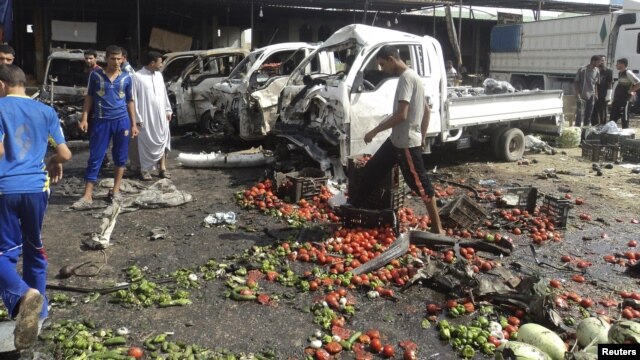 Residents inspect the site of a bomb attack in Karbala on July 3.