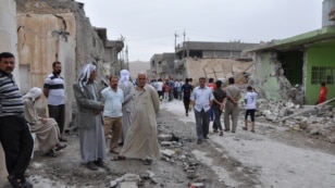 People inspect damage at the site of two car bomb blasts in the Iraqi town of Tuz Khormato on May 21.