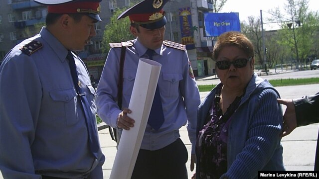 Полиция пытается увести активиста оппозиции Фатиму Касенову с митинга "Несогласных". Семей, 28 апреля 2012 года.
