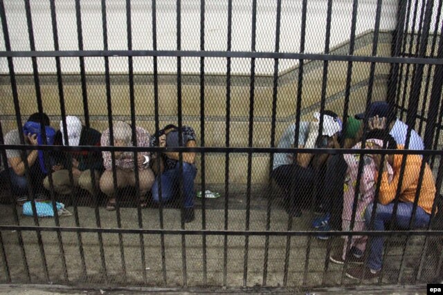Группа египетских мужчин в клетке в зале суда, задержанная за 
