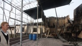 Ынтымақ ауылындағы өртенген үйге қарап тұрған адам. 11 ақпан 2015 жыл.