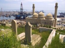 Azerbaijan -- Cemetery, mosque and Caspian Sea oil derricks, Baku, May 2003