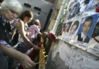 Women light candles in the destroyed school sport hall in Beslan, September 1, 2007. (AFP)