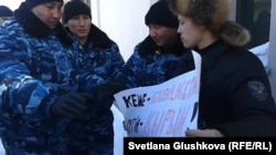 Kazakh police speak with Makhambet Abzhan (right) outside the Russian Embassy in Astana on March 3.
