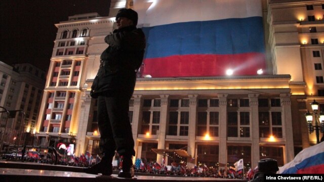 A police officer patrols next to a pro-Putin meeting on Manezh Square in Moscow on March 4.
