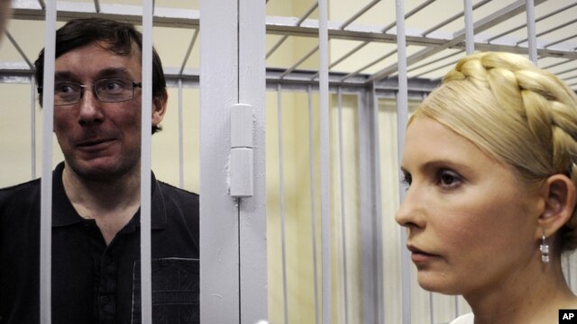 Former Ukrainian Interior Minister Yuriy Lutsenko (left) in a defendant's cage with former Prime Minister Yulia Tymoshenko in a courtroom in Kyiv in May 2011.