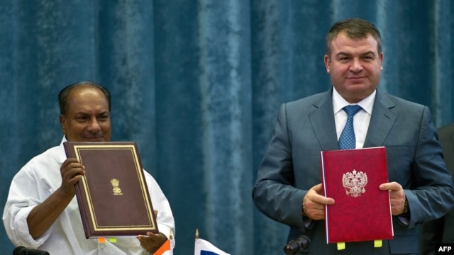 Indian Defense Minister A.K. Antony (left) and his Russian counterpart, Anatoly Serdyukov, pose with documents after agreement signing in New Delhi on October 10.