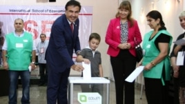 Georgia -- President Mikheil Saakashvili, accompanied by his wife Sandra Roelofs and son Nikoloz, casts his vote during a parliamentary election at a polling station in Tbilisi, 01Oct2012