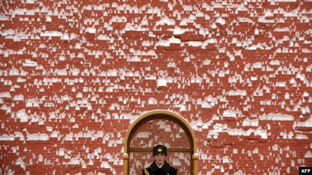 A crumbling facade? A guard stands guard at the Kremlin in Moscow.