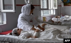 Wounded Afghan students from the American University receive treatment in the female ward at the Italian aid organization hospital in Kabul.