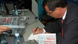 Евгений Жовтис жаңа кітабына қолтаңба жазып отыр. Алматы, 16 сәуір 2012 жыл.