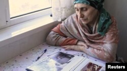 Patimat Suleimanova looks at photos from a family album at her house in Makhachkala on April 22. "He taught his own parents, his sisters, and his brother how to pray," she says of her nephew, Tamerlan Tsarnaev.
