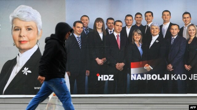 A man walks past a campaign poster of Prime Minister and President of the Croat Democratic Union (HDZ) Jadranka Kosor in downtown Zagreb on December 1.