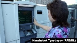 Банкоматтан ақша алып тұрған адам. Алматы, 21 маусым 2013 жыл. (Көрнекі сурет.)
