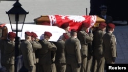 Polish soldiers carry the coffins holding bodies of the late President Lech Kaczynski and his wife Maria Kaczynska in Krakow.