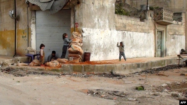 Children hide behind sandbags on the street in the central Syrian town of Rastan, near Homs.