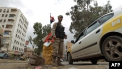 A Yemeni policeman stands at a checkpoint in the capital, Saana, where Britain, France, and Germany also closed their embassies.