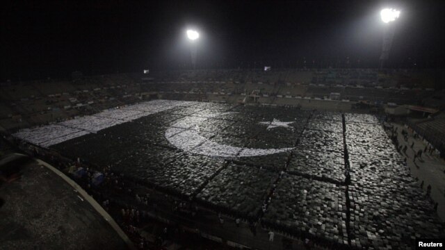 Students stand together to form the world's largest human flag to qualify for the Guinness World Records at the National Hockey Stadium in Lahore on October 22.