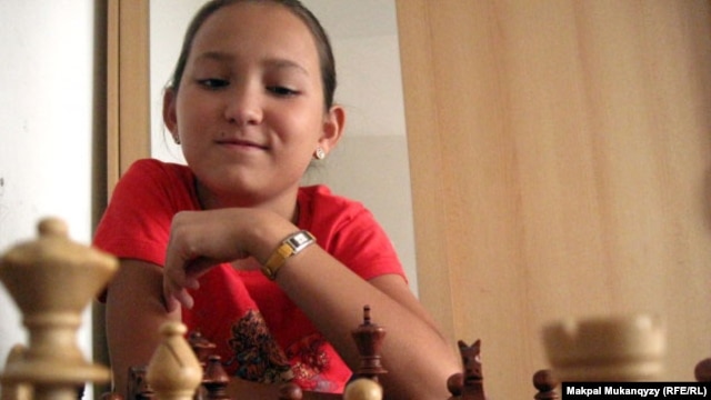 Жансая Абдумалик, трижды чемпион мира по шахматам среди детей, за шахматной доской. Алматы, 19 июля 2011 года.