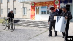 A Kyrgyz election worker carries a ballot box during voting in the town Belovodsk on September 30.