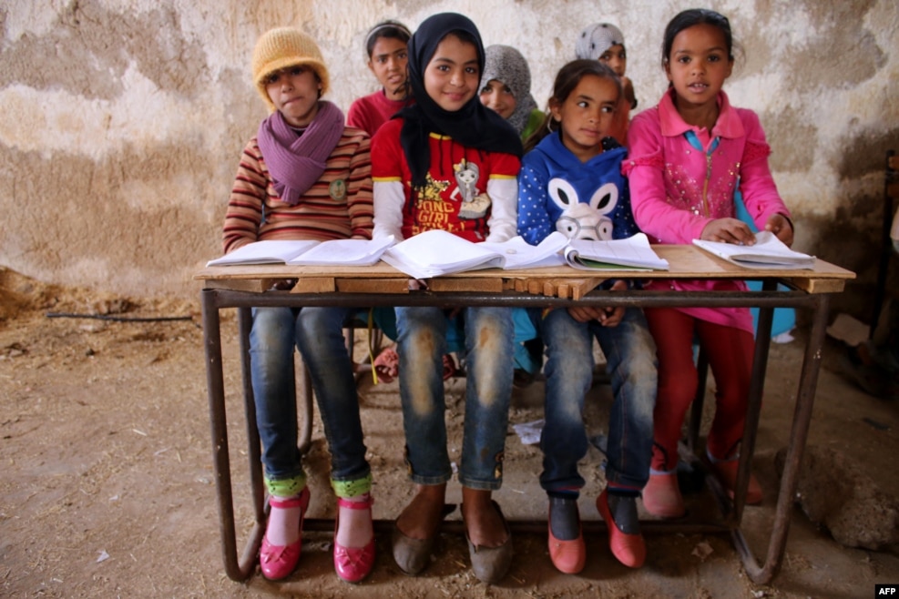 Syrian children sit during a class in a barn that was converted into a makeshift school to teach internally displaced children in a rebel-held area of Daraa, in southern Syria, on November 10. Rebels hold most of Daraa Province, but the regional capital is largely controlled by the government. (AFP/Mohamad Abazeed)