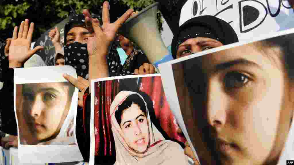 Islamist activists in Lahore carry photographs of Malala during a protest against the assassination attempt.