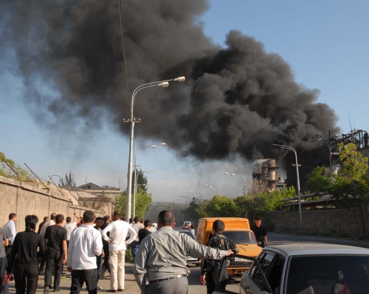 Armenia -- Onlookers watch as black smoke billows from the Nairit chemical plant in Yerevan hit by an explosion on 14May2009