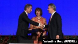 EU foreign policy chief Catherine Ashton looks on as Moldovan Prime Ministe Iurie Leanca (left) shakes hands with European Commissioner for Trade Karel de Gucht after the signing of an Association Agreement between Moldova and the European Union.