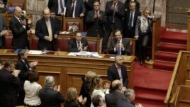 Prime Minister Antonis Samaras (blue tie) applauds with lawmakers after a vote at the parliament in Athens, on November 8.