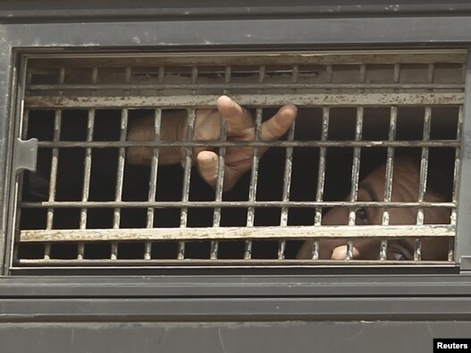 A Palestinian detainee gestures from the window of a bus as it leaves a jail ahead of a prisoner swap on October 18. 