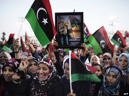 Women wave Libya's post-Qaddafi flag during celebrations in the streets of Tripoli after news of Muammar Qaddafi's capture and death on October 20.