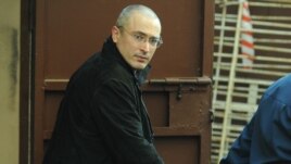 Handcuffed former Yukos head Mikhail Khodorkovsky is led away from Moscow's Khamovniki District Court