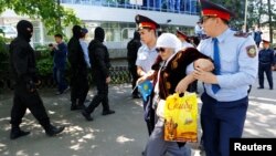 Полицейские производят задержание женщины в день протеста против земельной реформы. Алматы, 21 мая 2016 года.