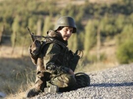 A Turkish soldier sits on a road in the province of Sirnak, near the Turkish-Iraqi border