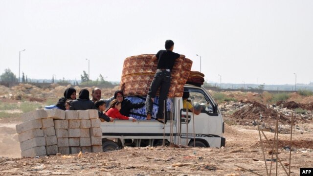 Syrian civilians flee the northern city of Aleppo during a lull in fighting between opposition forces and army troops on July 25.