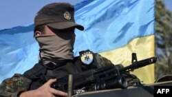 A volunteer for the Ukrainian paramilitary Azov Battalion waits on an armored vehicle, as pro-Russian separatists fire heavy artillery, on the outskirts of Mariupol on September 5.