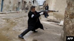 A rebel aims his weapon during clashes with government forces in the streets of Aleppo on March 4.