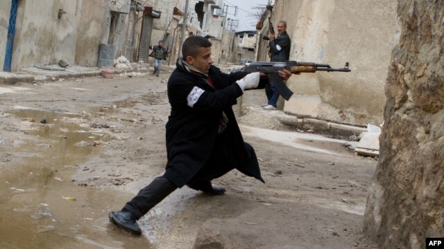 A rebel  aims his weapon during clashes with government forces in the streets of Aleppo on March 4.