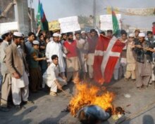 Pakistan - Supporters of a religious group, Jamiat-e-Talba-e-Arabia (JTA) chant anti-Danish and anti-French slogans as they burn a Danish flag to protest against the publication of cartoons depicting Prophet Mohammad, in Multan, 2 Feb. 2006