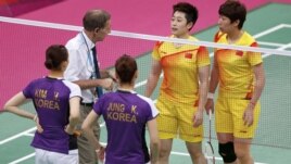 An official speaks to players from China and South Korea during their women's doubles badminton group match on July 31.