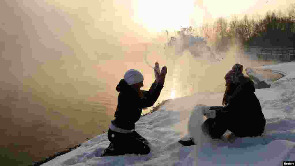 Two girls play in the snow on the bank of an island in the middle of the Yenisei River, where the air temperature reached minus 22 degrees Celsius, in the Siberian city of Krasnoyarsk. (Reuters/Ilya Naymushin)