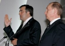 Russia -- Vladimir Putin listens as his Georgian counterpart Mikheil Saakashvili (L) speaks during their joint news conference following their meeting in St.Petersburg, 13June2006