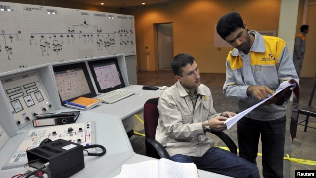 An Iranian operator (right) and a Russian operator discuss a document as they monitor the nuclear power plant unit in Bushehr.
